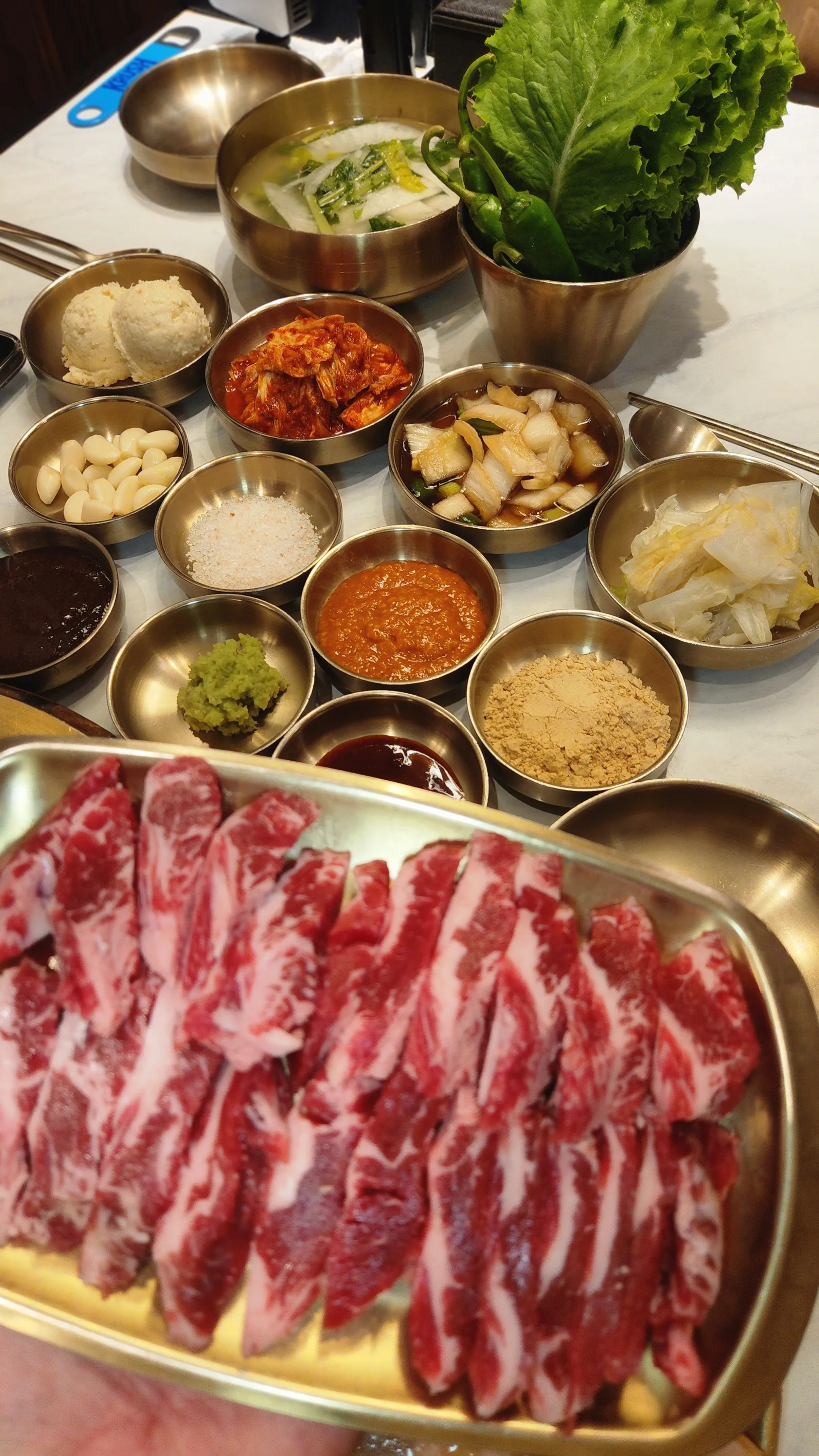 놋 반상과 황동 트레이에 담긴 생고기 한 상